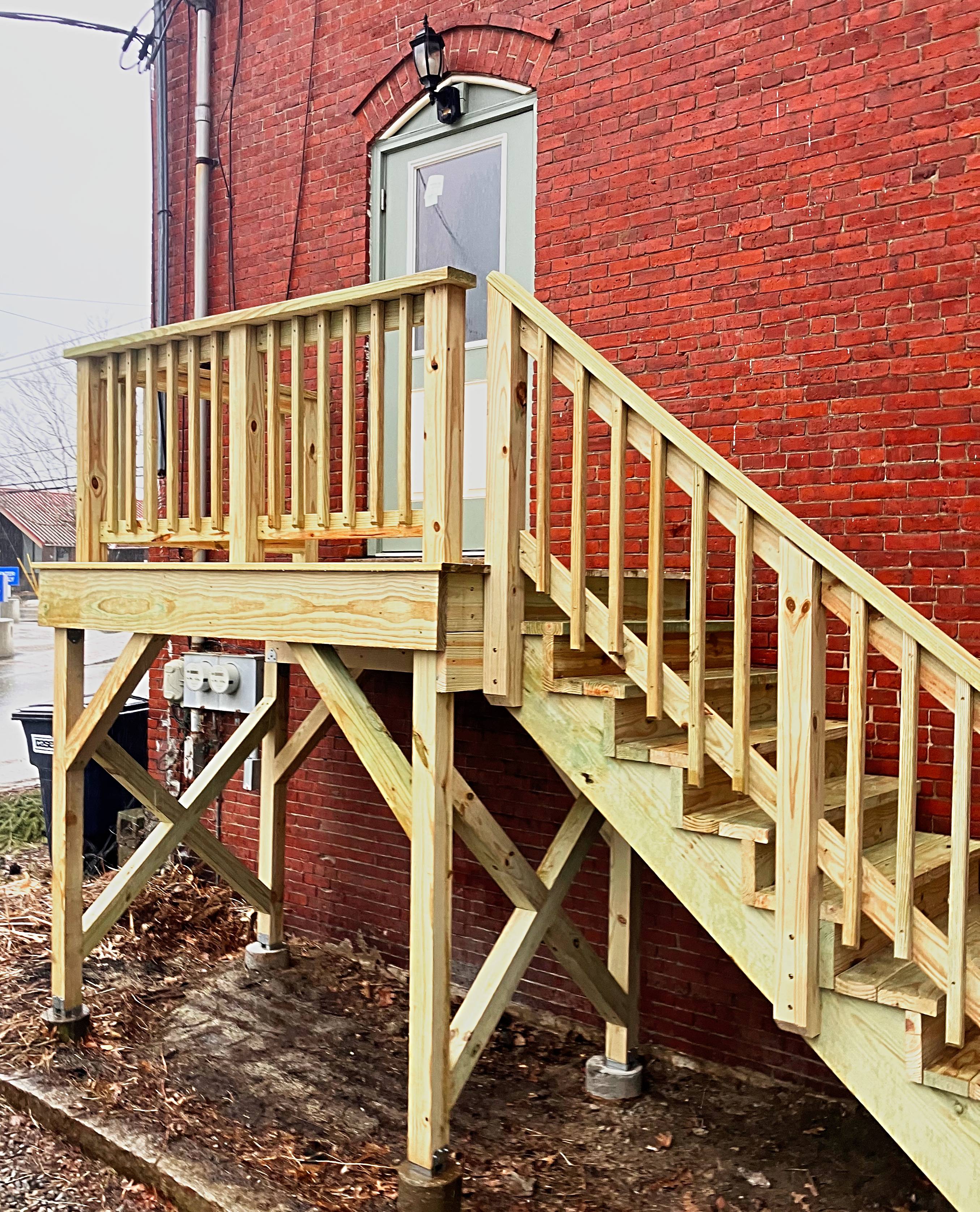 Rebuilt elevated deck and staircase on a brick building