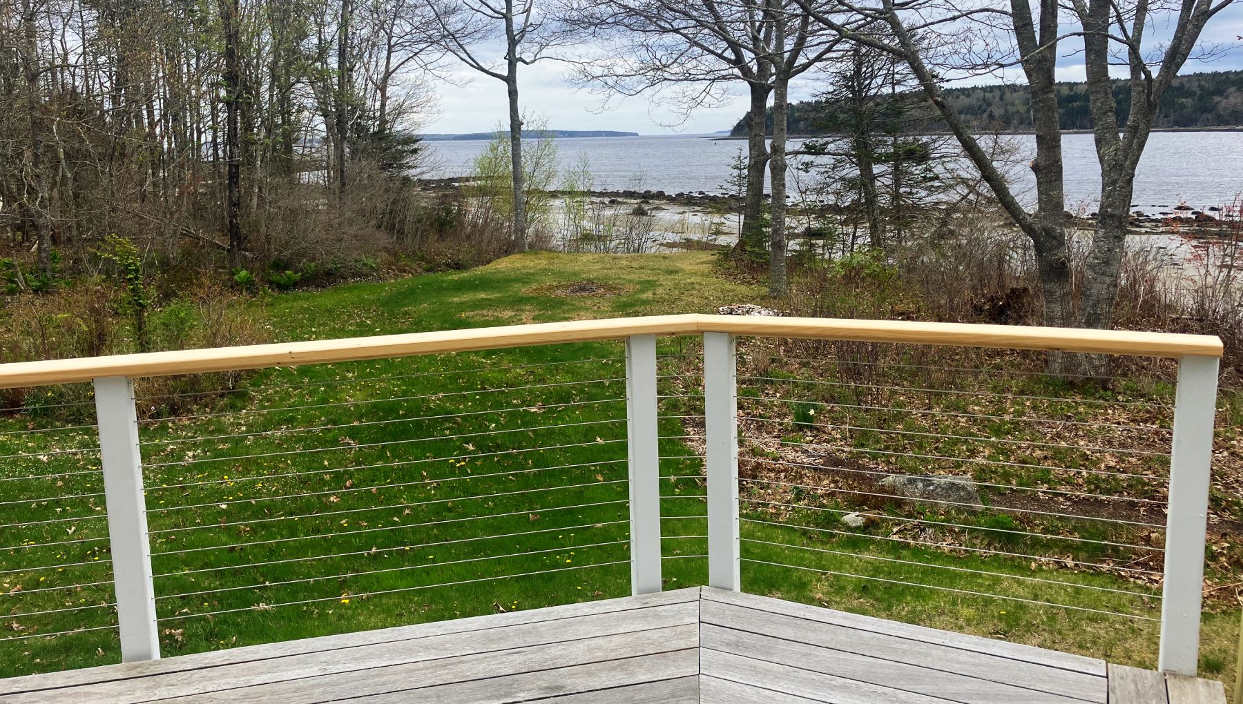 Waterfront deck with cable railing and Alaskan yellow cedar top cap